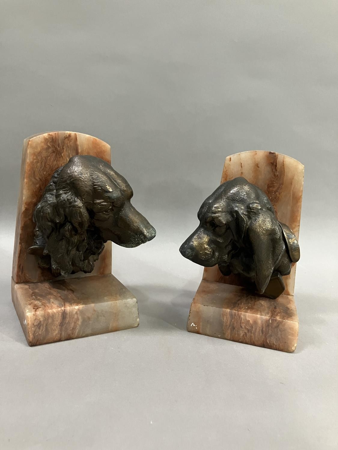 A pair of art deco bronze effect spaniel and blood hound bookends mounted on alabaster, 20cm high