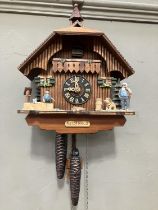 A Black Forest style cuckoo clock with swinging pendulum and weights having two figures , goats