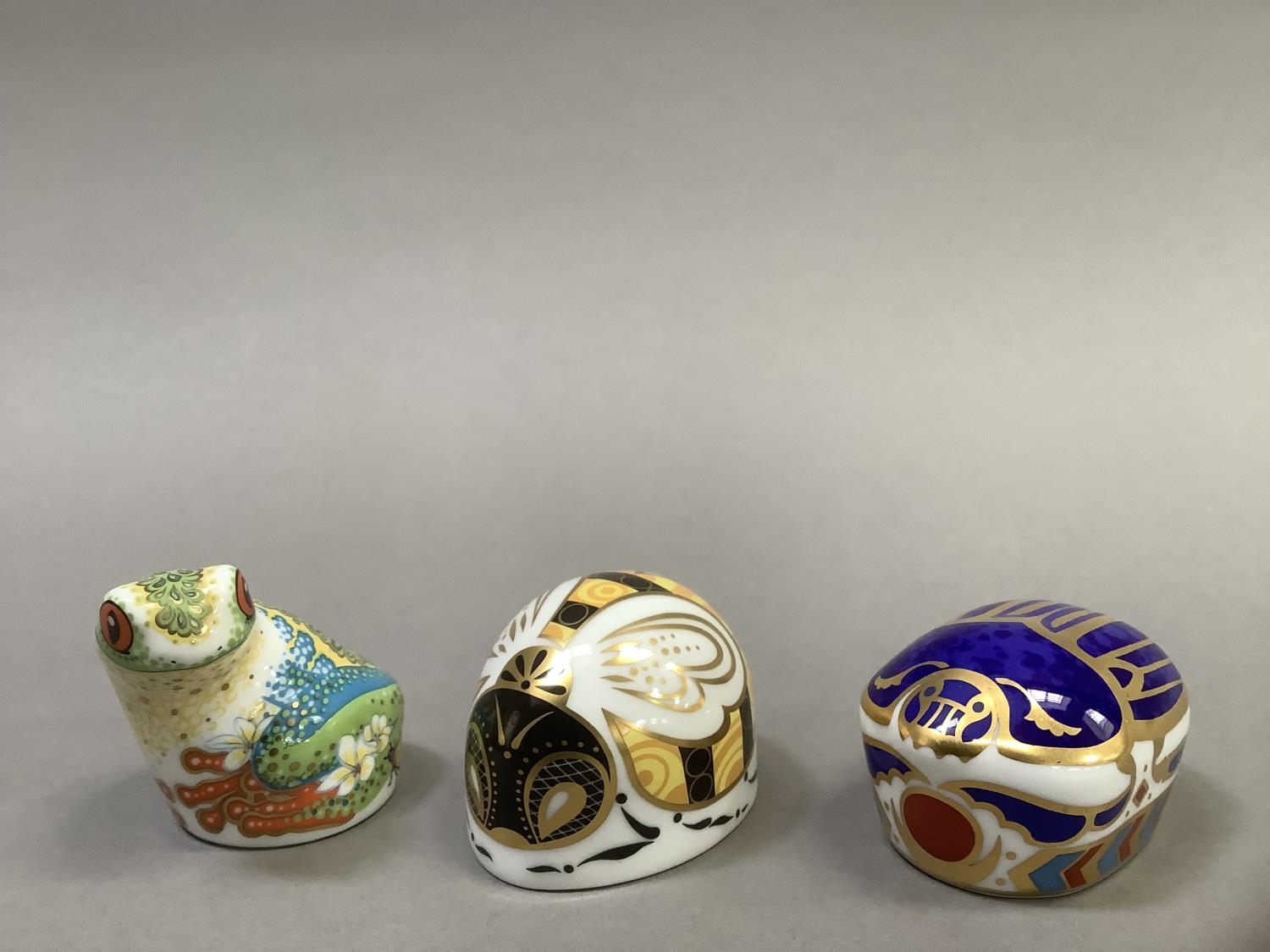 Three Royal Crown Derby paperweights, including a tree frog, bumble bee, for Collector's Guild and a