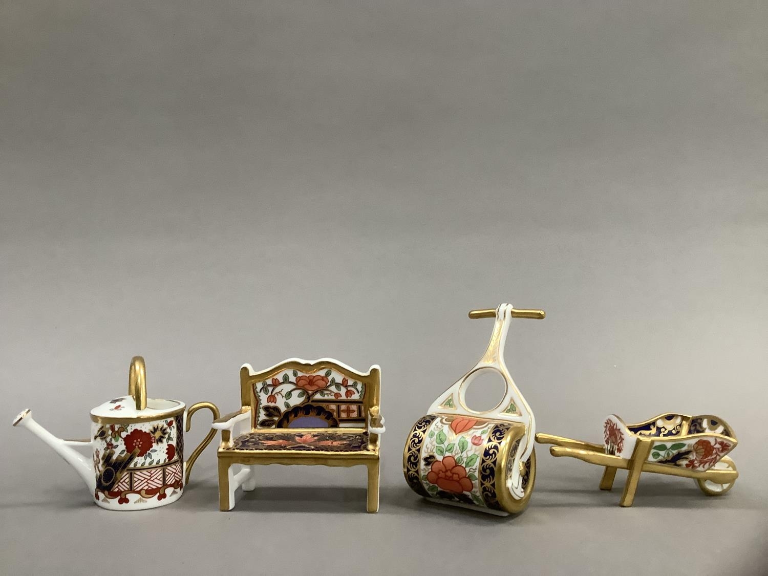 Four Royal Crown Derby miniatures including ag garden bench, watering can, wheelbarrow and garden - Image 2 of 4