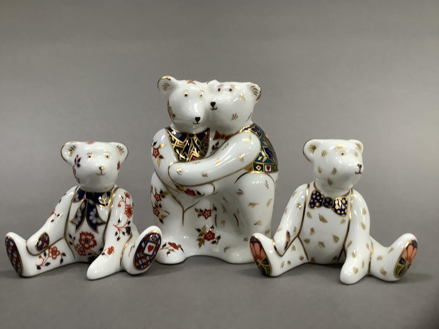 A Royal Crown Derby model of two bears hugging together with two seated bears, 9cm and 6.5cm