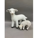 A ceramic figure of a lamb together with a smaller composite example