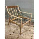 A 1960/70s blond wood armchair with railed back and rounded legs, in need of webbing and