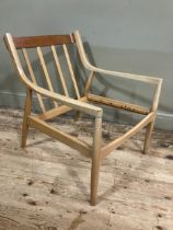 A 1960/70s blond wood armchair with railed back and rounded legs, in need of webbing and