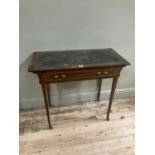 An Edwardian mahogany and satinwood banded writing table having a Rexine incised writing surface