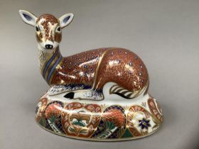 A Royal Crown Derby figure of a deer, recumbent, on an oval base, designed exclusively for the Royal