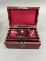 AN early 20th century jewellery case covered in faux red leather with tiered red velvet lining