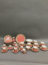 A Royal Worcester tea and coffee service of salmon pink ground over pale yellow printed with foliate