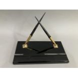 A Sheaffer's black and gilt metal desk standish with two fountain pens, each fitted with a 14K