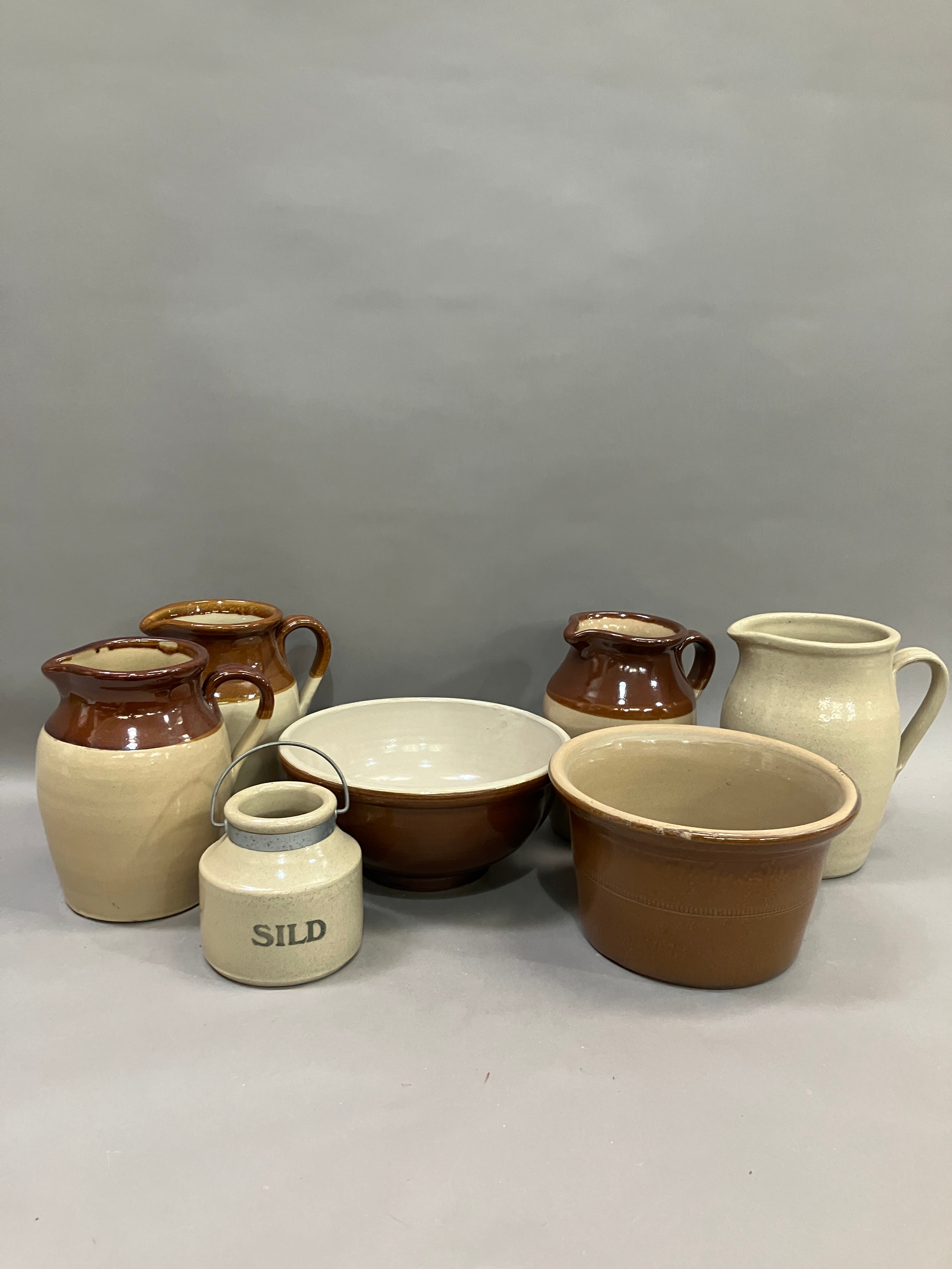 Three stoneware jugs with brown half glaze together with stoneware bowls another jug and a jar - Image 2 of 2