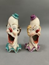 A pair of ceramic clowns heads on ruffled collars with gaping mouths, 15cm high