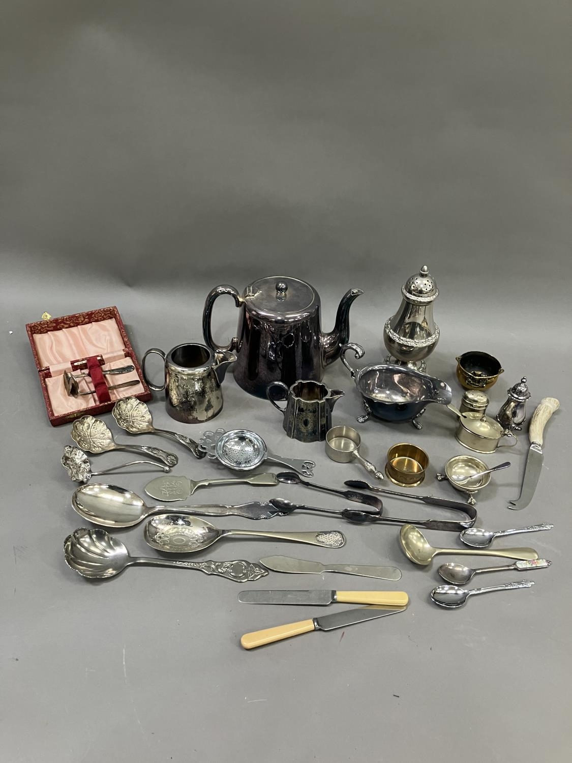 A collection of silver plated ware including sugar sifter, teapot, hot water jug etc
