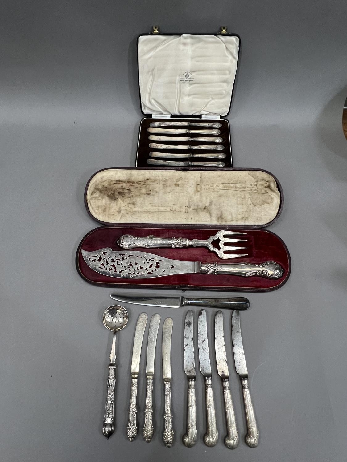 A boxed set of silver handled cake knives together with several other items of silver handled