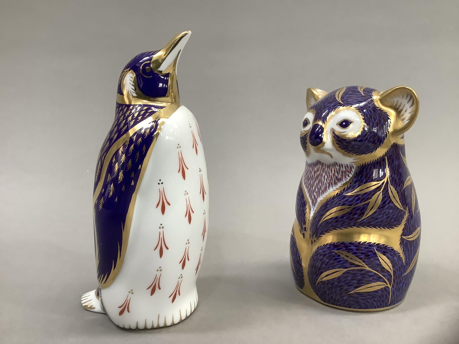 A Royal Crown Derby Koala bear paperweight and a penguin, gold button to one, 11cm and 13.5cm high