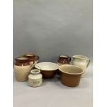 Three stoneware jugs with brown half glaze together with stoneware bowls another jug and a jar