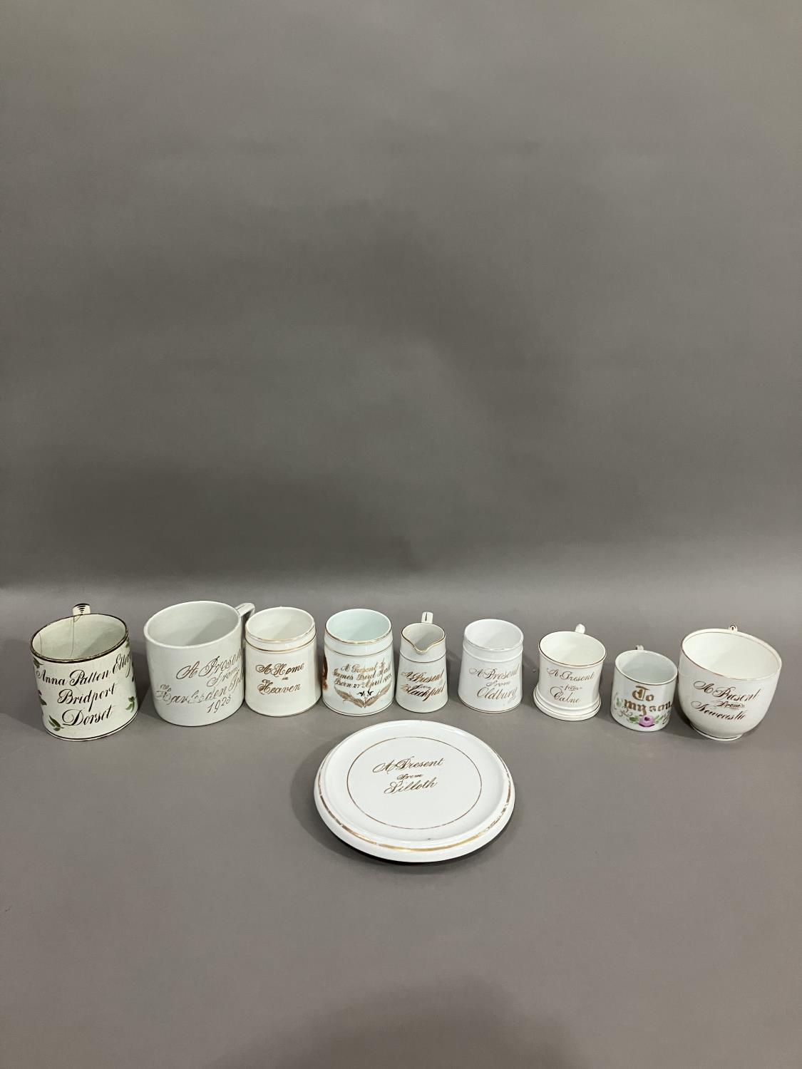 A collection of 19th and early 20th century named mugs, jugs and teapot stand, some souvenirs from