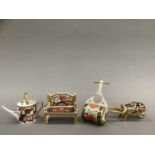 Four Royal Crown Derby miniatures including ag garden bench, watering can, wheelbarrow and garden