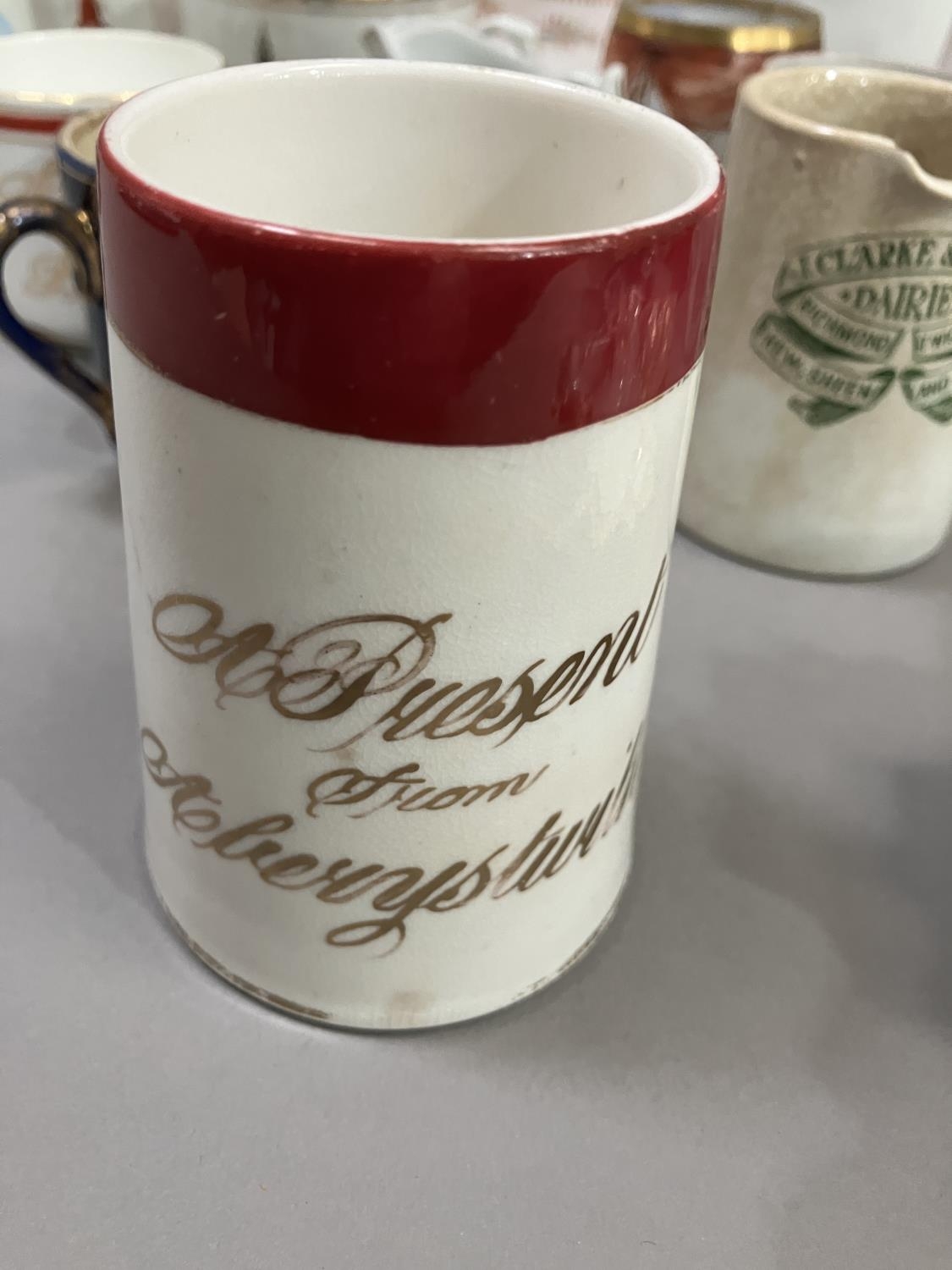 A large quantity of Victorian and later souvenir mugs including two with whistle bird handles, a jug - Image 6 of 10