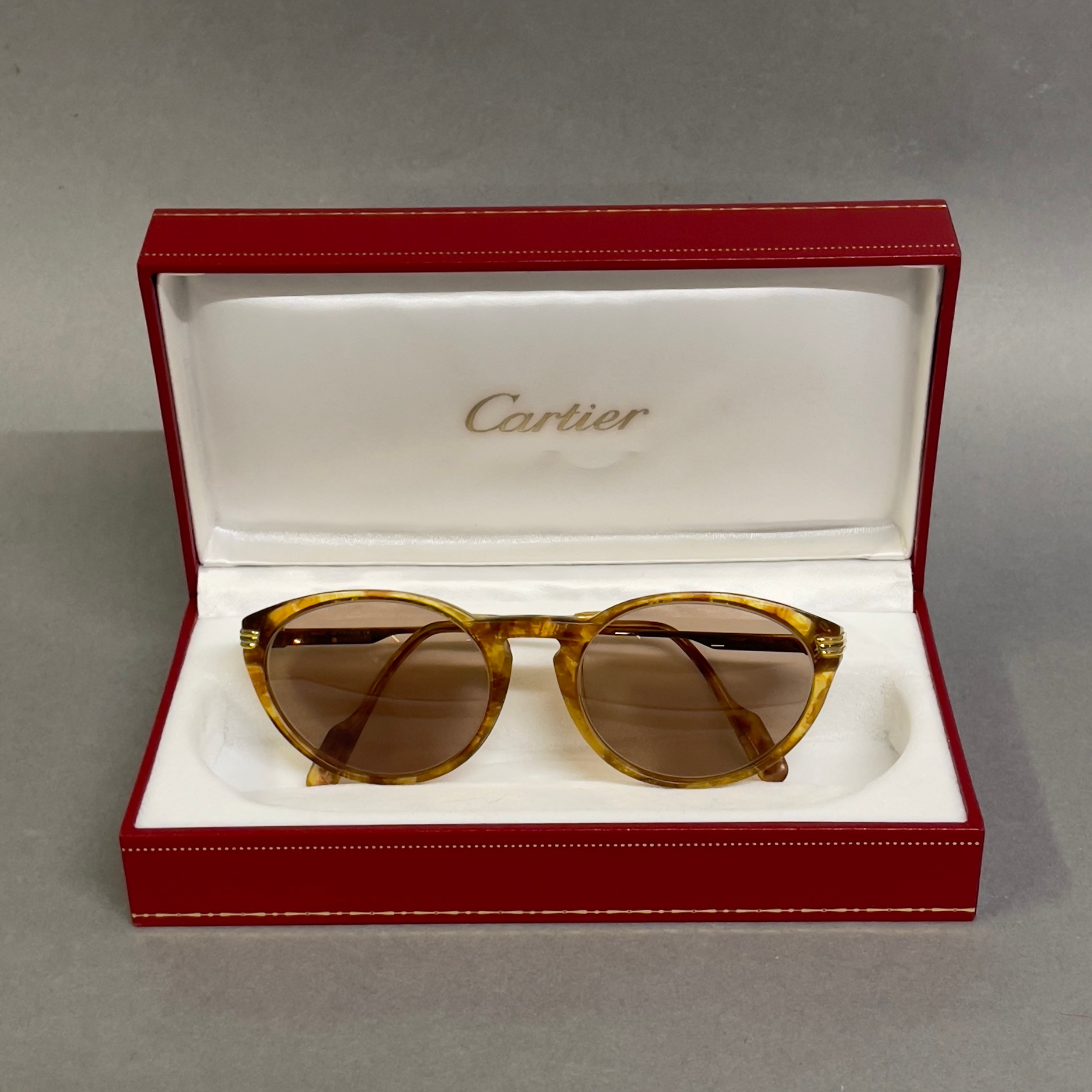 A pair of Aurore Cartier prescription sunglasses with marbled frames signed Cartier, I.D card in