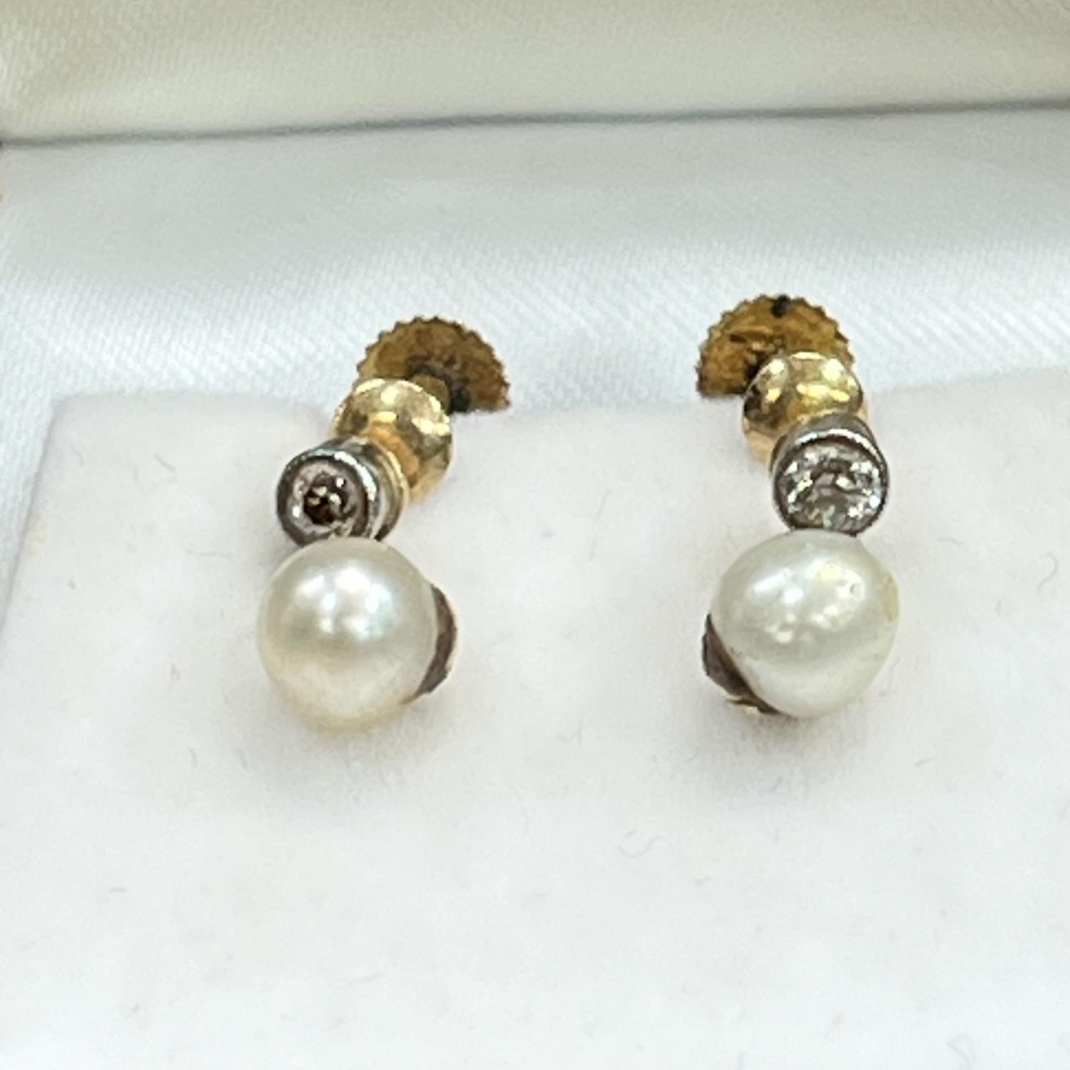 A pair of cultured pearl and diamond earrings, c1920, in 9ct gold, each 5.5mm pearl pendant from a