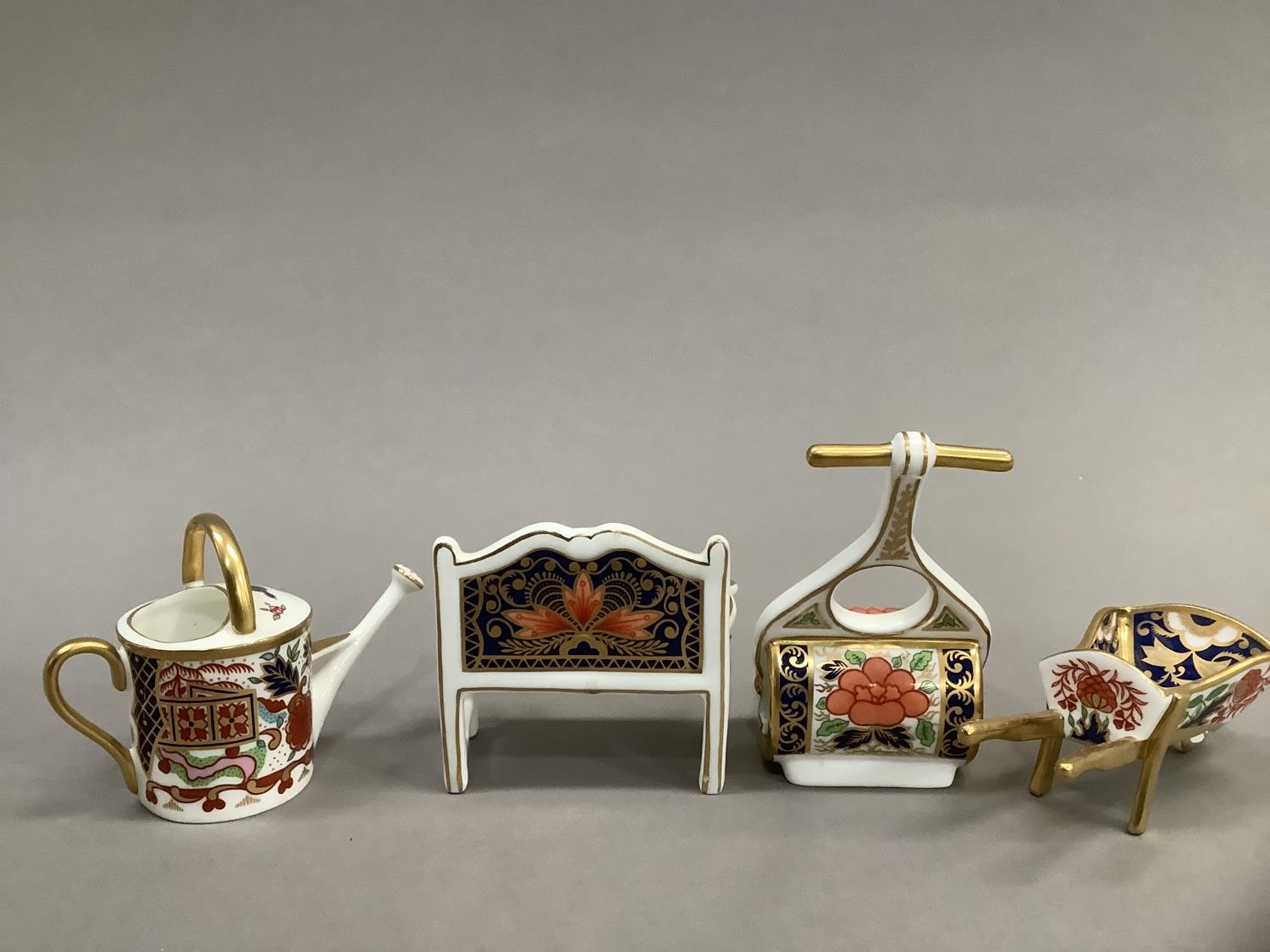 Four Royal Crown Derby miniatures including ag garden bench, watering can, wheelbarrow and garden - Image 3 of 4