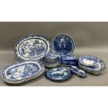 A collection of blue and white ware including 19th century willow pattern plates, later wild rose