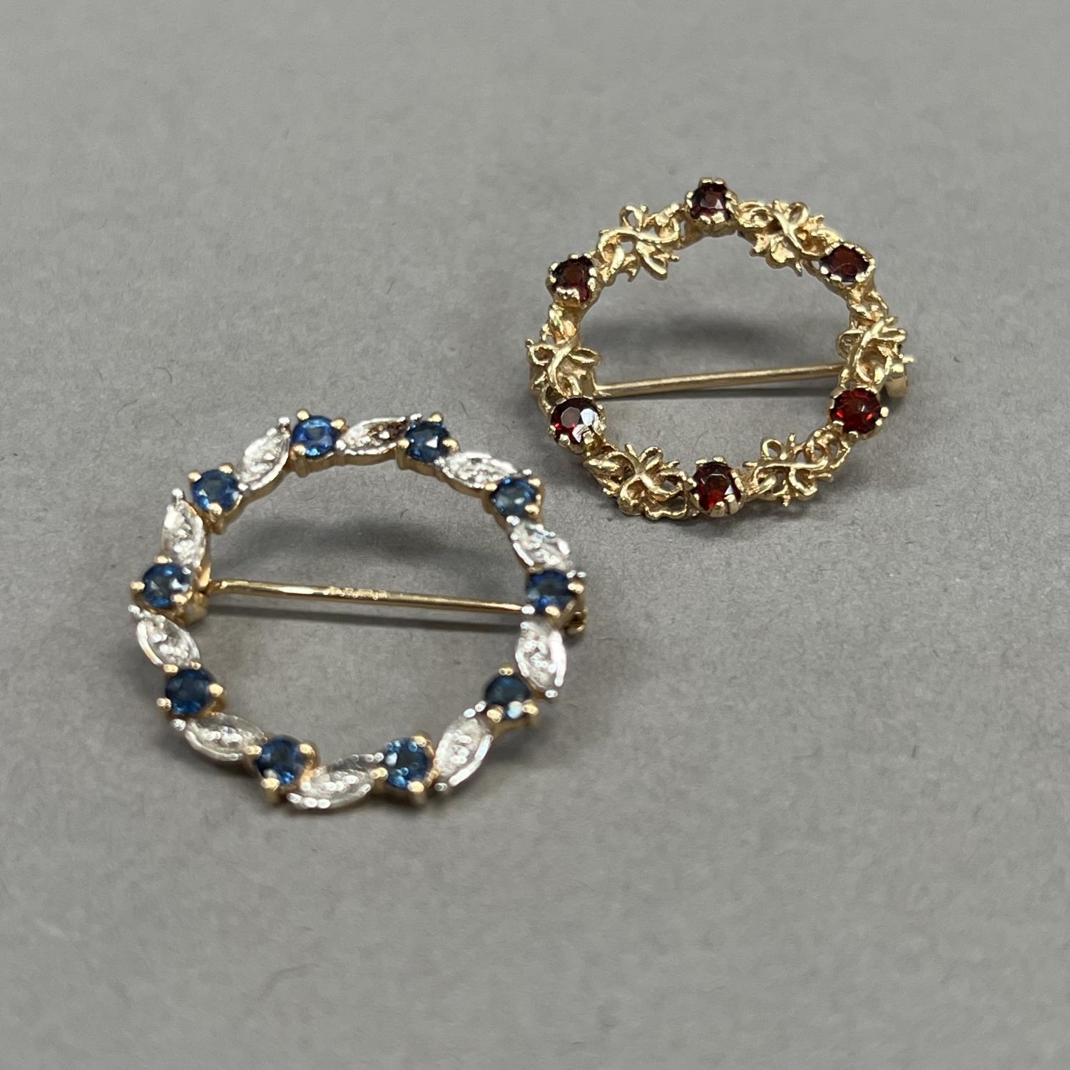 A sapphire and diamond wreath brooch in 9ct gold claw and grain set with small eight cut diamonds