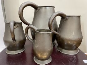 A set of four copper jugs of graduated size measuring 28cm over handle, 22.5cm and 16cm