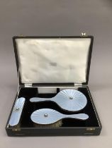 A silver and blue enamel three piece dressing table set, in fitted case,
