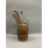 A brass bound and oak coopered barrel stick stand with swing handle together with several walking