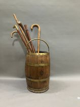 A brass bound and oak coopered barrel stick stand with swing handle together with several walking