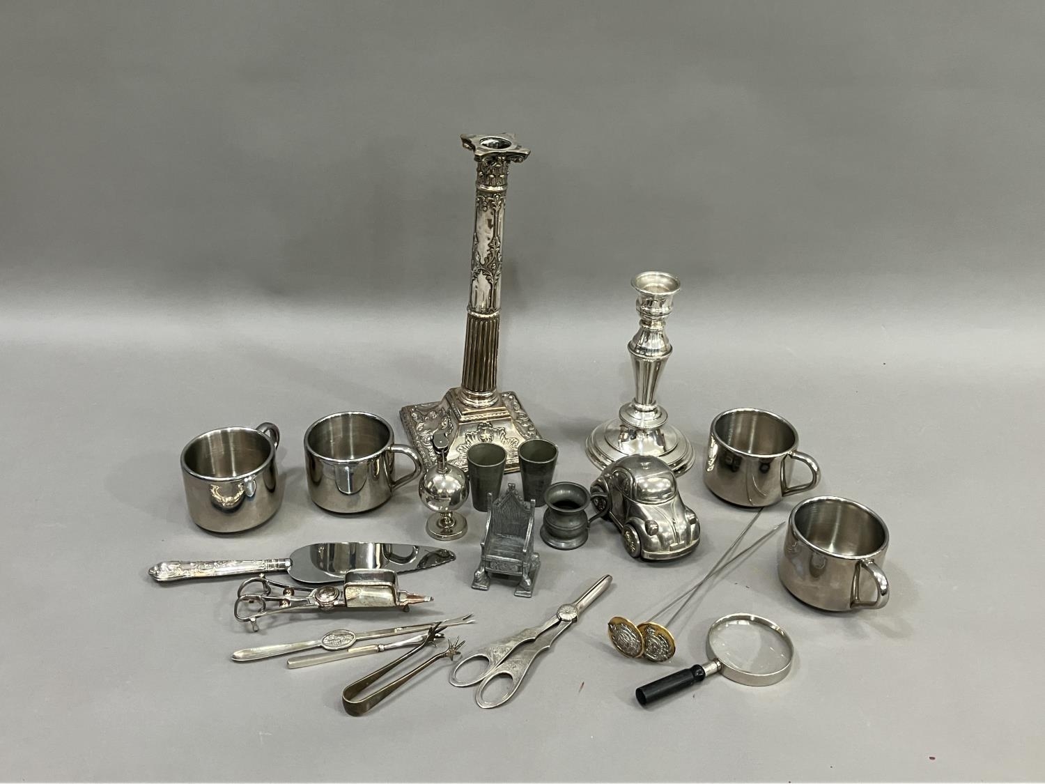 A moulded silver plate on copper candlestick, another silver plate candlestick, two pairs of