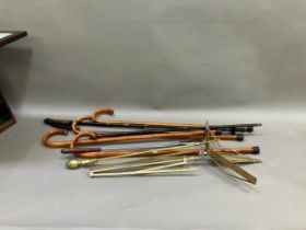 A collection of five walking sticks, one walking pole and a brass fire poker, together with trolley,