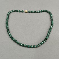 A Malachite bead necklace, each 6mm spherical bead interspaced with a small 9ct gold bead,