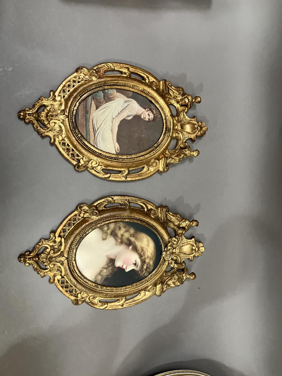 A pair of gilt metal wall hanging picture frames having pierced and moulded decoration, the pediment