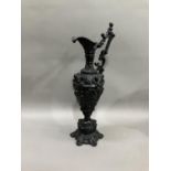 A French black cast metal and heavily moulded ewer, the handle surmounted by cherub, 45cm high