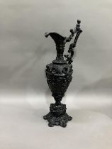 A French black cast metal and heavily moulded ewer, the handle surmounted by cherub, 45cm high