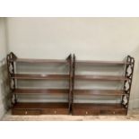 A pair of mahogany reproduction wall shelves with cut sides, having four tiers with two drawers,