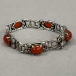 A silver and cornelian bracelet, c1966, each foliate link of rectangular outline, claw set with an