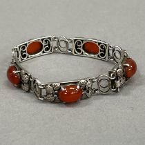 A silver and cornelian bracelet, c1966, each foliate link of rectangular outline, claw set with an