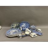 A collection of blue and white ware comprising several willow pattern meat plates, willow pattern