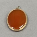 A Cornelian pendant in 9ct gold, the oval double cabochon stone collet set in 9ct gold,