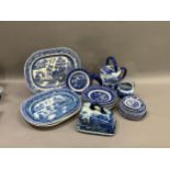 A collection of blue and white ware including four willow pattern meat plates, side plates, dinner