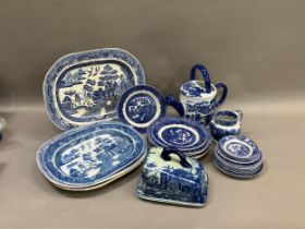 A collection of blue and white ware including four willow pattern meat plates, side plates, dinner
