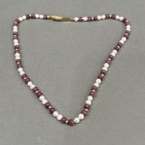 A seed pearl and ruby bead necklace, the approximate 4.5mm diameter spherical ruby beads interspaced