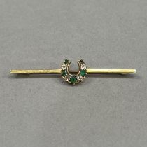 A Victorian Demantoid garnet and diamond horseshoe stock pin in 15ct gold, on a 9ct rose gold pin,