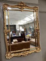 A gilt framed rectangular wall mirror having a shell and rocaille frame and inner slip, 109cm x 75cm