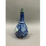 A 19th century Middle Eastern earthenware bottle in grey white and painted in blue with lozenge