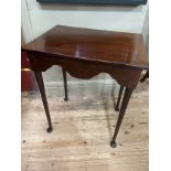 An 18th century and later mahogany table, rectangular, having a deep wavy apron, slender rounded