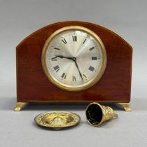 An Edwardian mahogany mantel clock inlaid with box wood and ebony stringing, arched profile on brass